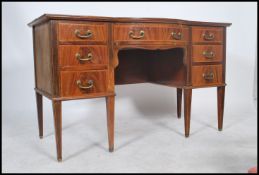 A 19th century Georgian mahogany breakfront kneehole desk being raised on squared legs with a series