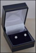 A pair of ladies 14ct white gold and diamond stud earrings approx 70pnts total being claw mounted.