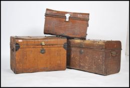 A group of three vintage 20th century industrial luggage tin trunks having folding handles to
