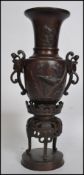 A pair of bronze twin handled Chinese vases. Each of baluster form having pierced twin handles