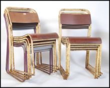 A stack of mid century Industrial school hall / workmans club stacking chairs having panel seats