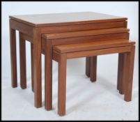 A vintage retro Air Ministry nest of three teak wood graduating tables raised on square legs and