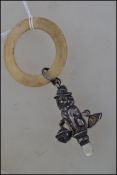 An Edwardian silver hallmarked babies rattle in the form of a Lion wearing a hat, bells to the