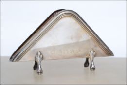 A continental stamped 800 silver letter rack of triangular form, geometric border raised on four pad