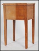 A 1920's retro golden oak pedestal sewing box being raised on squared tapered legs with spade feet