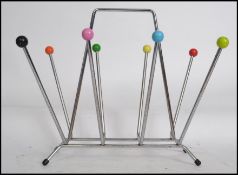 A mid 20th century retro sputnik atomic magazine rack of tubular form having alternating coloured