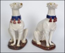 A pair of Italian white glazed pottery models of seated greyhounds, 20th century, modelled
