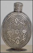 A silver lidded perfume bottle having a screw top lid with floral and leaf decoration and border