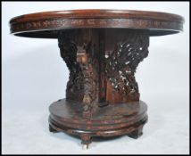 A believed 19th century Chinese hardwood table being profusely carved with symbols and characters.