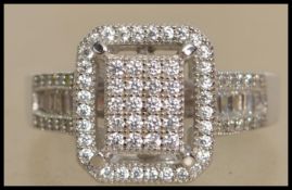 A ladies contemporary silver and cz pave set Art Deco style dress ring having further halo surround.