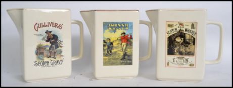 A group of three breweryania advertising point of sale pub whisky jugs for Johnny Walker, Lairds and