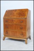 A 1930's Art Deco walnut bureau desk having a fall front slope with appointed interior set over a