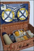 A retro vintage 20th century wicker picnic hamper with hinged lid opening to reveal a fitted
