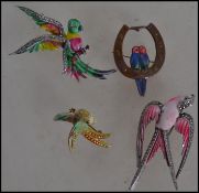 A group of four vintage 20th century costume jewellery brooches in the form of enamel and