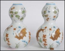 A pair of believed 19th century Oriental ceramic small gourd vases having bulbous bodies and necks