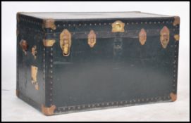 A large vintage metal bound steamer travelling trunk, with locking mechanism, hinged lid and