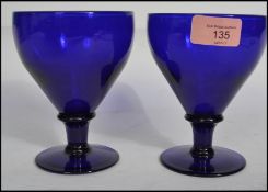 A pair of 19th century Victorian Bristol Blue glass rummer's raised on plain bases with knopped
