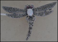 A ladies Art Nouveau silver and marcasite dragon fly brooch having inset oval cabochon stone, pine