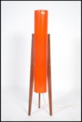 A 1970's retro teak atomic rocket lamp being raised on tapering supports with vibrant cylinder shade