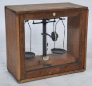 A cased set of early 20th century scientific scales with glass oak case having inset scales complete