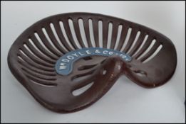 A vintage style WM and Co Doyle tractor seat having a pierced base with lipped rim and detailed