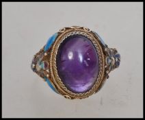 A believed Victorian silver and enamel set gypsy ring having an inset cabochon amethyst type stone