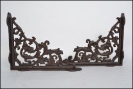 A pair of vintage style cast iron architectural wall brackets of angular form having a rococo