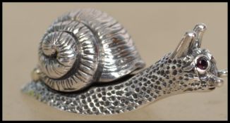 A cast silver figure of a snail being marked Sterling to the base.Total weight 10.5g / 3cms long