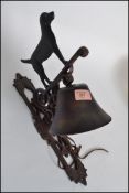 A vintage style cast iron dog bell having a rococo style angular wall bracket pierce decorated