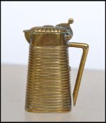 A vintage early 20th century brass vesta in the form of a covered  ribbed jug having hinged top