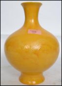 A 19th century Chinese yellow monochrome glaze vase of baluster form being decorated with dragons