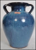 A large 20th century studio art pottery three handled baluster vase having a bulbous body with