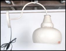 A vintage retro industrial style outdoor factory type yard light having a tubular scroll arm