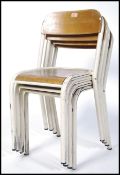 A stack of 4 mid century Industrial school hall  childrens stacking chairs having wooden ply panel