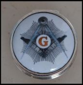 A gentlemans silver and enamel pill box of circular form having enamel top with masonic symbols.