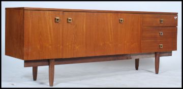 A 1970's retro Danish style teak wood sideboard raised on shaped supports with a series of cupboards
