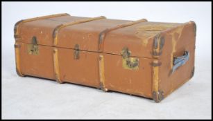 A vintage 20th century canvas and wooden bound steamer trunk having three lock catches to front with