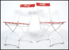 A pair of original 20th century metal Coca-Cola folding cafe chairs with red plastic slatted