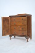 A 1930's oak estate cabinet chest of drawers. The cabinet with twin doors housing a series of