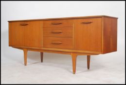 A 1970's Danish style sideboard of low and long form having tapered legs with a series of drawers
