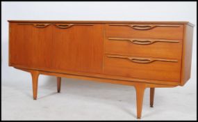 A 1970's retro teak wood sideboard of Danish influence by Jentique. Raised on shaped legs with