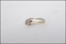 A hallmarked 9ct white gold single stone diamond solitaire ring having sloped shoulders with a