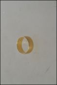 An 18ct gold hallmarked band ring. London hallmarks. Total weight 5.7g / Size O