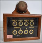 An Edwardian servants 8 division bell casing / butlers call box with a wooden casing and glass front