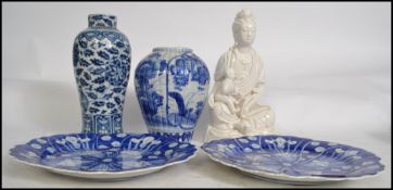 A Chinese Blanc De Chine deity porcelain glazed figurine with seated child. Together with 2 blue and