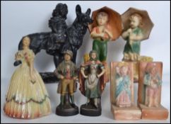 A group of vintage early 20th century chalk ware figurines to include a girl with dog, a pair of