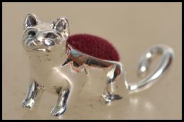 A miniature silver pin cushion in the form of a cat having inset baize lined cushion atop. Weight