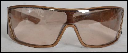 A pair of vintage Dior Italian made sunglasses in a gold tone colour with five stars to each arm.
