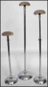 A set of three 1930s Art Deco chrome wig stands raised on circular bases having adjustable central