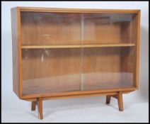 A 1970's Herbert Gibbs teak wood glass sliding door window bookcase with inset shelves and on